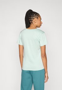 Μέντα πράσινο κοντομάνικο μπλουζάκι με στρογγυλή λαιμόκοψη. Μαλακό ύφασμα με διακριτική υφή. Συνδυάζεται με τυρκουάζ παντελόνια που έχουν άνετη γραμμή.