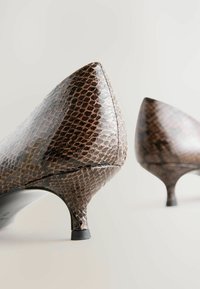 Spitz zulaufende Absatzschuhe aus strukturiertem, braunem Kunstleder in Schlangenoptik mit glänzender Oberfläche, ausgestattet mit einem schlanken Absatz und dezenten Nähdetails.