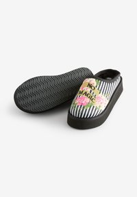 Czarno-białe buty wsuwane w paski z kwiatowym wzorem, z napisem "NO MAGIC". Teksturowana gumowa podeszwa i wyściełane wnętrze.