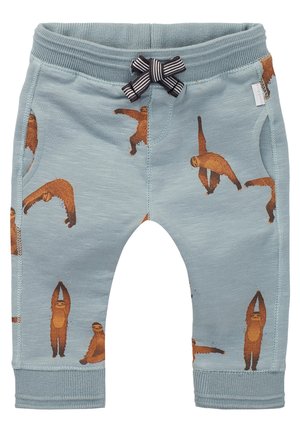 Niebieskie spodnie dziecięce z brązowymi ilustracjami leniwców w różnych pozach oraz czarno-białą paskowaną kokardką na pasie.