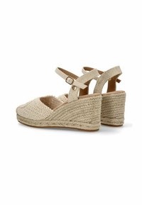 Sandali con tacco a zeppa intrecciati beige, con una tomaia texturizzata, cinturino alla caviglia regolabile e una piattaforma in juta intrecciata. Design ergonomico per il massimo comfort.