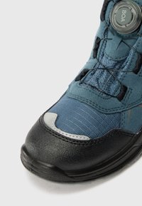Blaue Wanderschuhe mit strukturiertem Obermaterial, schwarzem Gummi-Zehenkappenschutz und einem BOA-Zugverschluss-System. Glatte und langlebige Materialien wurden durchgängig verwendet.