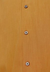 Pomarańczowa koszula z teksturowanej tkaniny, z pięcioma guzikami z przodu, wykonana z lekkiego materiału, oferująca swobodny wygląd.