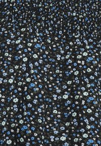 Tecido com padrão floral em fundo preto, apresentando pequenas flores azuis e brancas. O franzido texturizado na parte superior adiciona dimensão.