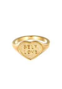 Gouden hartvormige ring met de geëmbosserde tekst "ZELF LIEFDE" op een gestructureerd oppervlak, met een gepolijst bandje en een gladde binnenkant.