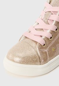 Μπλεττερ παπούτσι με ροζ κορδόνια και λευκή σόλα, με χρυσά οφθαλμοφυτικά και μια μικρή χρυσή λεπτομέρεια αστεριού στο πλάι.