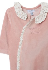 Prenda de bebé de terciopelo rosa con un cuello de volantes de estampado floral y texto en relieve "la flor de mamá" en el pecho. Cierre a presión en el cuello.