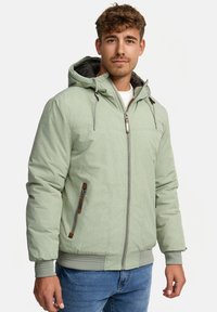 Mint green jacket with a hood, zip closure, and side pockets. Features a textured fabric and brown accents on zippers and drawstrings.