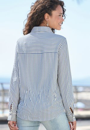 Striped long-sleeve shirt in cream and navy, featuring a button-down collar, cuffs with buttons, and a relaxed fit.