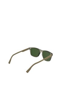 Lunettes de soleil avec une monture rectangulaire, avant gris clair, verres verts olive et branches beige. Design minimaliste avec des accents métalliques.