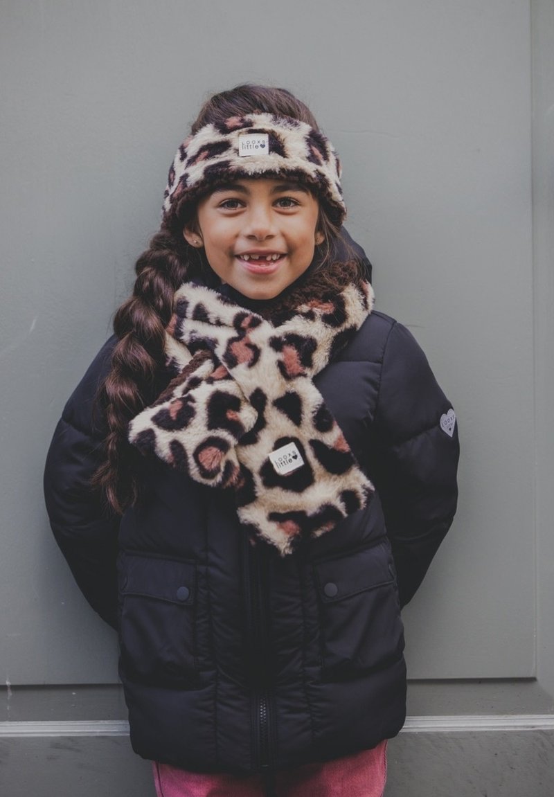 Zwarte gewatteerde jas, sjaal van luipaardprint en haarband. De sjaal valt om de nek, de haarband ligt op het haar, beide hebben een zachte textuur.