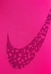 Bright pink t-shirt made of smooth fabric, featuring a large dark pink Nike swoosh logo with a textured pattern across the design.