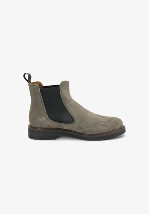 Stivale Chelsea in suede grigio con pannelli elastici, dettagli brogue, punta tonda e un bordo in pelle marrone a contrasto. Suola in gomma nera.