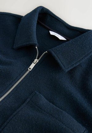 Marineblaue Wollmischung Jacke mit Kragen, Frontreißverschluss und einer einzelnen Tasche. Strukturiertes Gewebe und silberne Reißverschlussbeschläge.