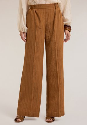 Pantaloni a gamba larga di un caldo colore marrone, con righe verticali e tessuto strutturato. Vita elasticizzata, abbinati a tacchi aperti.