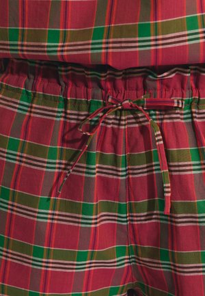 Czerwona, zielona i brązowa tkanina w kratkę z elastycznym pasem i wiązanym ściągaczem na środku.