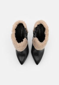 Stivaletti neri in pelle con punta affusolata, dotati di un colletto morbido color cammello, cerniera laterale e texture liscia.