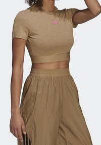 T-shirt khaki corta con girocollo, maniche corte e finitura testurizzata. Presenta un'etichetta con logo rosa sul davanti.