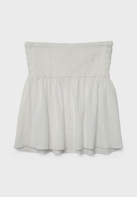 Haut blanc sans bretelles avec un corsage smocké et un tissu ample et fluide sous la taille, présenté sur un fond uni.