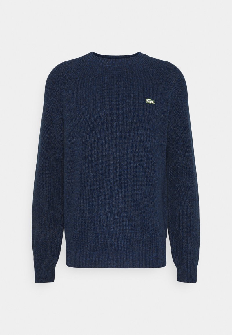 Pull en maille bleu marine à col rond, avec des manches longues et un petit logo crocodile vert sur la poitrine gauche.