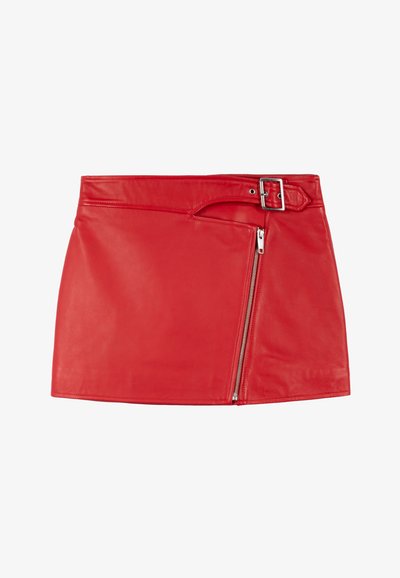 Mini-jupe en cuir rouge avec une fermeture éclair latérale et une passants pour ceinture. Texture lisse, coupe ajustée et ourlet asymétrique.
