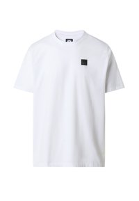 T-shirt bianca in cotone con maniche corte, scollatura a girocollo e una piccola toppa nera con il logo sull'area sinistra del petto.