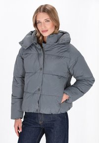 Grå pufferjakke med høj krave, knaplukning og kviltet design. Har en hætte og en let løs pasform med sidelommer.