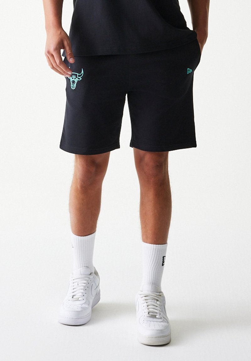 Μαύρα σορτς φούτερ με ανοιχτό μπλε λογότυπο ταύρου στο αριστερό μηρό, από απαλό ύφασμα, συνδυασμένα με λευκές κάλτσες και αθλητικά παπούτσια.