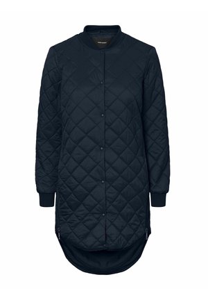 Veste longue matelassée bleu marine avec un ourlet arrondi, des poignets à côtes et des boutons-pression. Texture lisse avec un motif en losange. Poches latérales zippées.