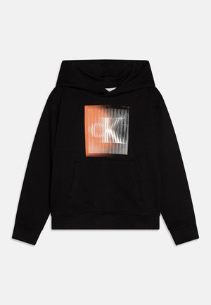 Zwarte hoodie met een voorzak, voorzien van een grafische print die overgaat van oranje naar grijs. Zachte stof met een ontspannen pasvorm.