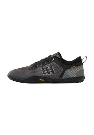 Zapatilla deportiva negra y gris con acentos amarillos, diseño de cordones, suela texturizada y tira de agarre en el talón, mostrada en perfil lateral.