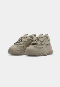 Beige Sport Sneakers mit Mesh- und Gummielementen, strukturierten Sohlen, doppelten Zuglaschen und flachen Schnürsenkeln. Klobige Silhouette mit abgerundetem Zehenbereich.