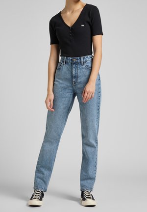 Sort ribbet kortærmet top med knapper, parret med høj talje blå denim jeans. Jeansene har en klassisk lige ben silhuet.