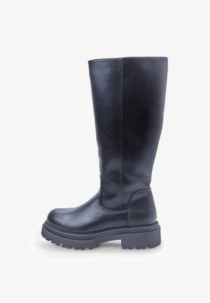 Czarne skórzane buty za kolano z grubą podeszwą o wyraźnym bieżniku i zaokrąglonym czubkiem, widok z boku na białym tle.