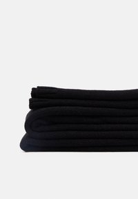 Tessuto nero arrotolato impilato in tre strati con un motivo a maglia testurizzato. Ogni strato è disposto in modo ordinato e uniforme in forma e dimensione.