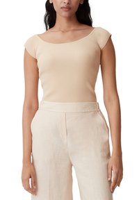 Beige ribbetop med bred krave og korte ærmer, parret med lyse beige linnedbukser. Glat tekstur og tætsiddende design.