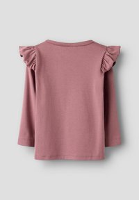 Długa koszula z długim rękawem w stonowanym różowym kolorze, z falbaniastymi akcentami na ramionach i okrągłym dekoltem. Gładka faktura i prosty design.