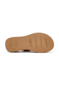 Suola di scarpa in gomma marrone chiaro con una superficie liscia, caratterizzata da cinque scanalature orizzontali per una migliore aderenza e una leggera curvatura sul tallone.