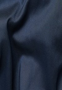 Tessuto di un blu scuro con una superficie liscia, leggermente lucida e un sottile motivo a trama diagonale, che presenta una caduta morbida e un movimento della superficie delicato.