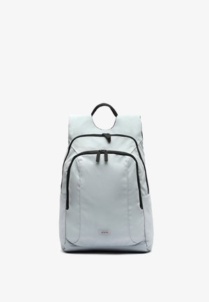 Hellgrauer Rucksack mit zwei vorderen Reißverschlusstaschen, schwarzen Reißverschlüssen, einem oberen Griff und einem kleinen rechteckigen Logo-Patch unten in der Mitte.