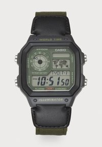Montre numérique avec un boîtier rectangulaire noir, écran LCD vert, bracelet en cuir et accent textile vert olive. Les caractéristiques incluent une alarme et l'heure mondiale.