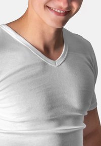 White cotton V-neck t-shirt with a fitted design. Smooth texture, short sleeves, minimal seams, and a clean, simple neckline.