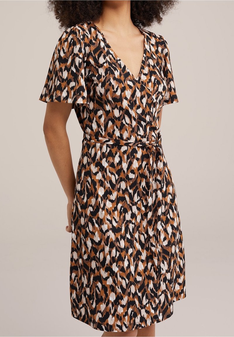 Robe imprimée léopard avec un décolleté en V, des manches courtes, une taille cintrée et un tissu fluide dans des tons terreux de marron, noir et blanc.