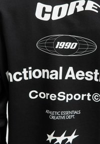 Hanorac negru cu text și grafică albă îndrăzneață, inclusiv "CORE", "1990" și "Aestetica Funcțională". Material moale din bumbac.