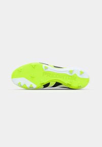 Des semelles de chaussures de soccer Predator avec un design noir et jaune fluo. Comprend des crampons moulés pour une meilleure traction et des détails de surface texturée.