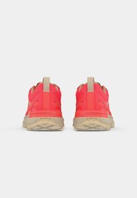 Pair of bright coral sneakers with beige soles and pull tabs, shown from the back on a white background.