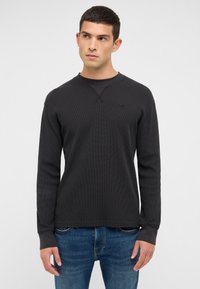 Fekete, hosszú ujjú, texturált, kerek nyakú pulóver bordázott mandzsettákkal, finom logóval a mellkason és laza szabással.