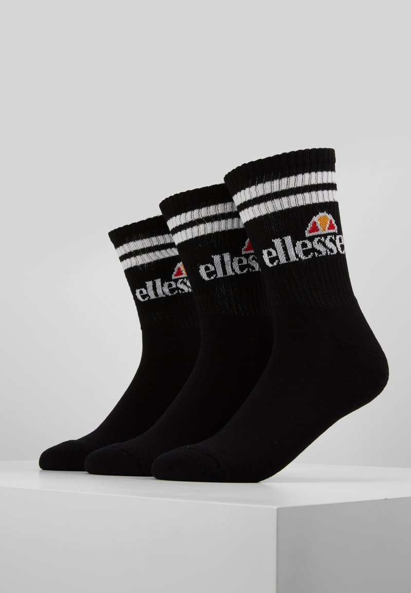 Calze di cotone nere con righe bianche in alto, caratterizzate da un logo che combina un triangolo e del testo. Tre paia esposti insieme.