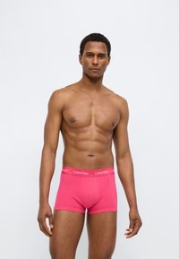 Ανδρικά ροζ βαμβακερά boxer briefs με ανάλογο ελαστικό ζωνάρι μέσης που φέρει το λογότυπο «Calvin Klein». Απαλή υφή και εφαρμοστή σχεδίαση.