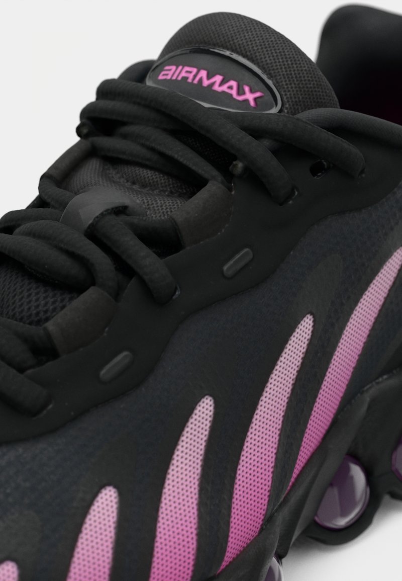 Schwarze Sneaker mit Mesh-Obermaterial, pinken Akzenten und Gummisohle. Verfügt über eine abgerundete Ferse und ein auffälliges Schnürsystem. "AIR MAX"-Logo an der Zunge.